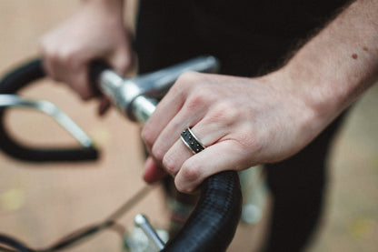 cool ring placed on a man's hand on a bicycle