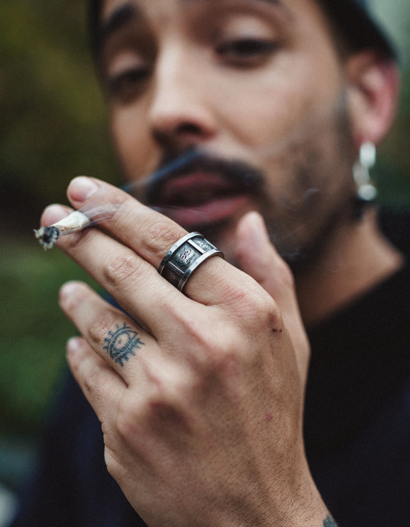 Man smoking a cigarrete with a cool statement ring